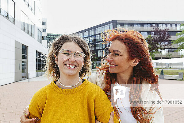 Happy redhead woman with daughter standing at Hafencity