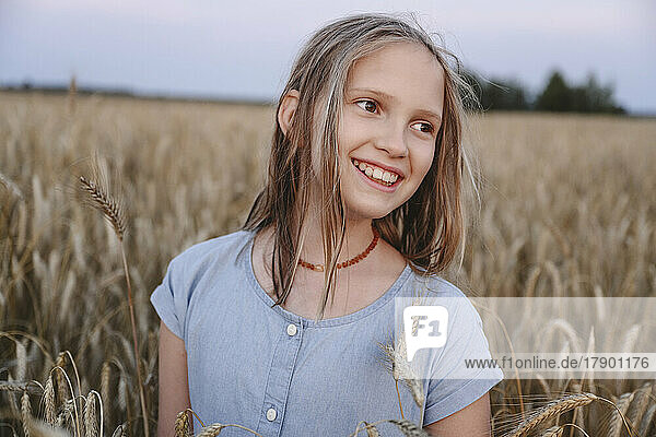 Smiling girl amidst crops in farm