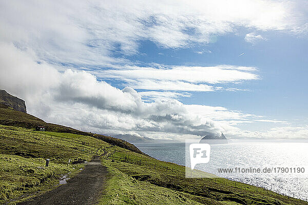 Faroe Islands  Vagar  Clouds over coastal dirt road with islands in background