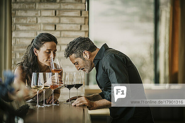 Mature couple smelling wine in glasses at restaurant