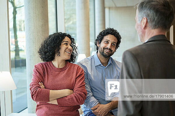 Happy multiracial colleagues discussing in office