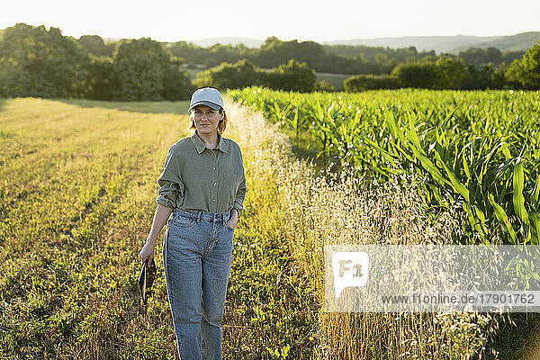 Woman standing in field holding digital tablet