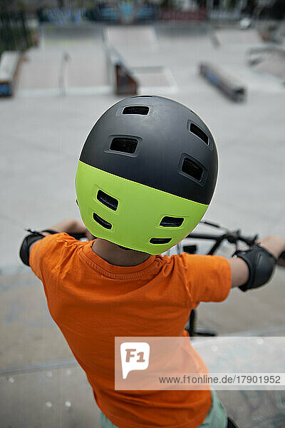 Boy with helmet on BMX bike at skate park