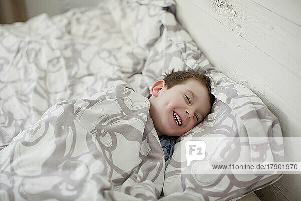 Happy boy enjoying bedtime at home