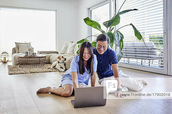 Happy freelancers sharing laptop at home