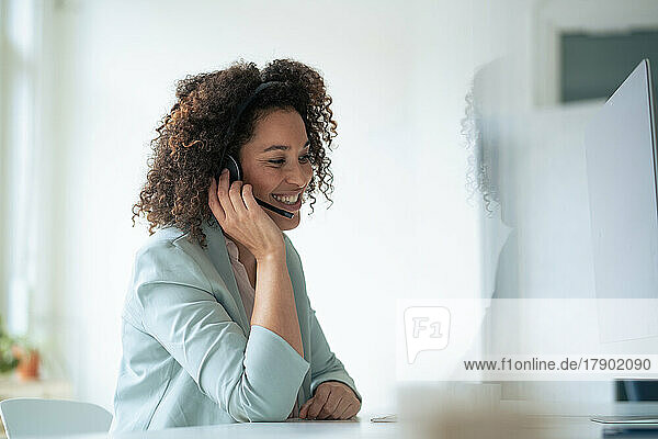 Happy businesswoman wearing headset at workplace