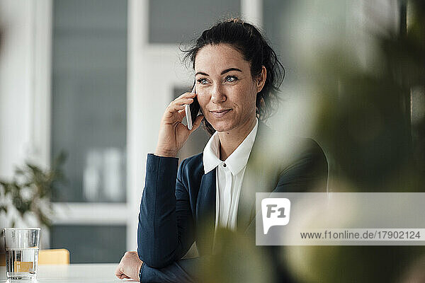 Lächelnde Geschäftsfrau  die am Handy spricht