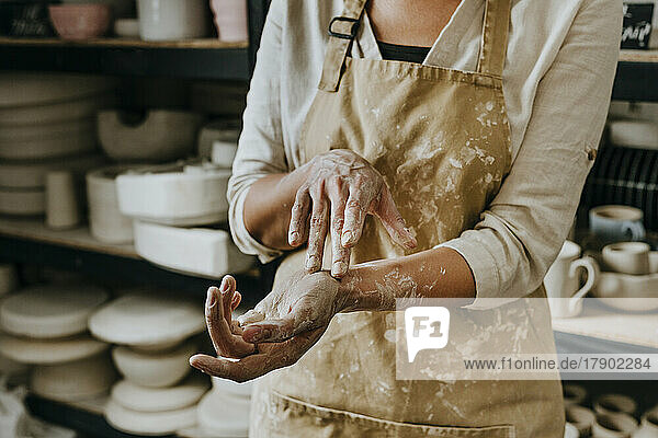 Schmutzige Hände einer Handwerkerin in der Werkstatt