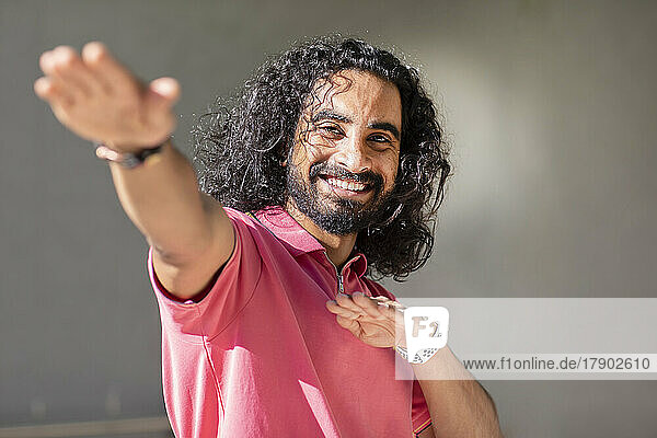 Smiling bearded man gesturing on sunny day