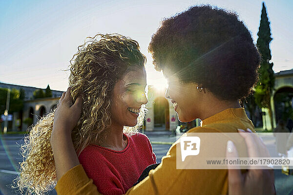 Smiling lesbian couple embracing on sunny day