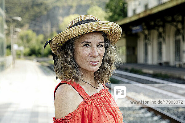 Senior woman wearing hat at railroad station