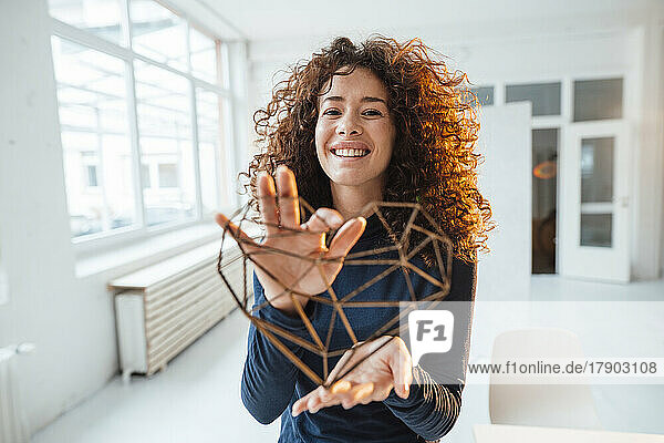 Happy young woman showing heart shape model