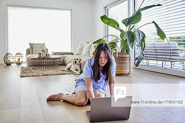 Freelancer using laptop on floor at home