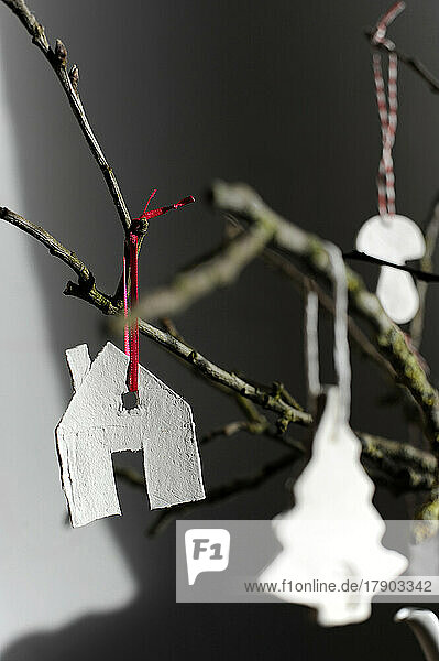 Simple house-shaped decoration hanging on twig