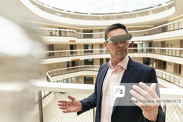 Reifer Geschäftsmann beobachtet durch VR-Brille im Flur