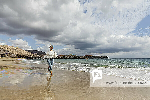 Young woman running on seashore at beach