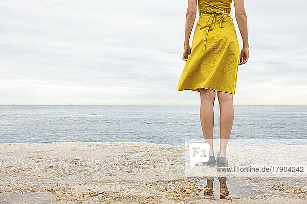 Woman standing on promenade near sea