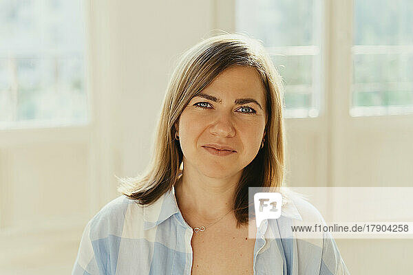 Smiling beautiful woman in front of window at home