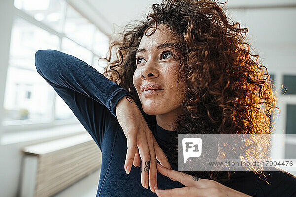 Smiling thoughtful woman with curly hair