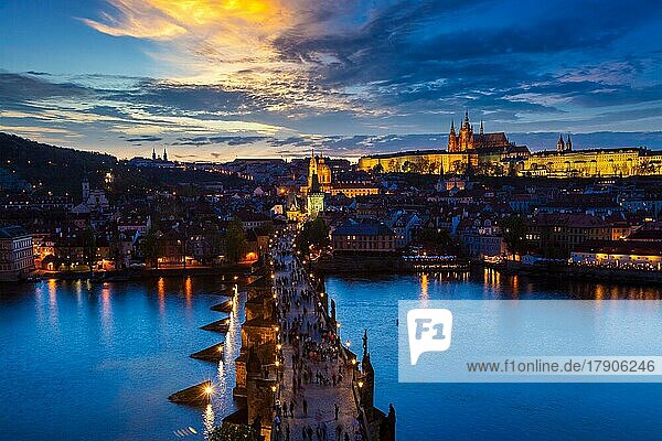 Aerial view of illuminated Prague castle and Charles Bridge with tourist crowd over Vltava river in Prague  Czech Republic. Prague  Czech Republic in the evening