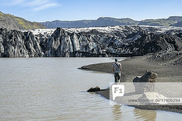 Tourist am Seeufer einer Gletscherlagune  Gletscherzunge und See  Sólheimajökull  Südisland  Island  Europa