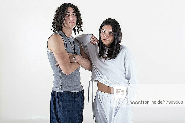 Portrait of a young couple dressed in yoga clothes looking ti the camera white background. Studio shot