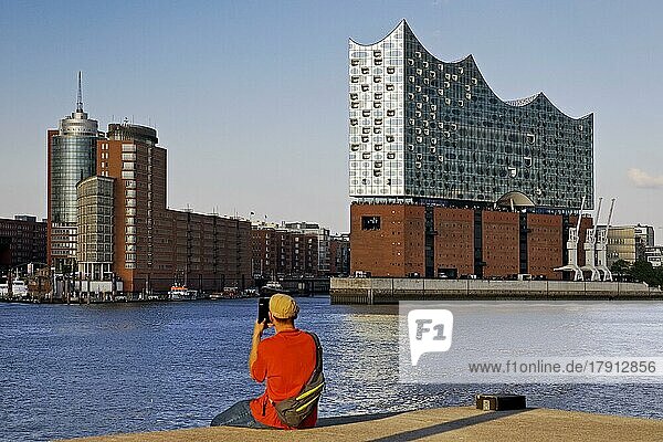 Ein Mann fotografiert die Elbphilharmonie und das Columbus Haus  Hafencity  Hamburg  Deutschland  Europa