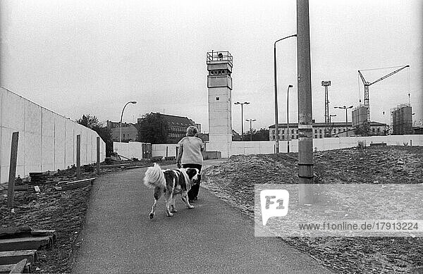 DDR  Berlin  07. 06. 1990  Mauer an der geschichtsträchtigen Bernauer Straße (Nordbahnhof)  Frau mi Hund  Wachturm  © Rolf Zoellner