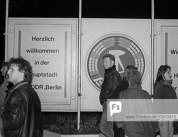DDR  Berlin  09. 11. 1989  Öffnung der Berliner Mauer  Grenzübergang Bornholmer Straße  DDR Embleme und Willkommensgruß  DDR Bürger strömen in den Westen