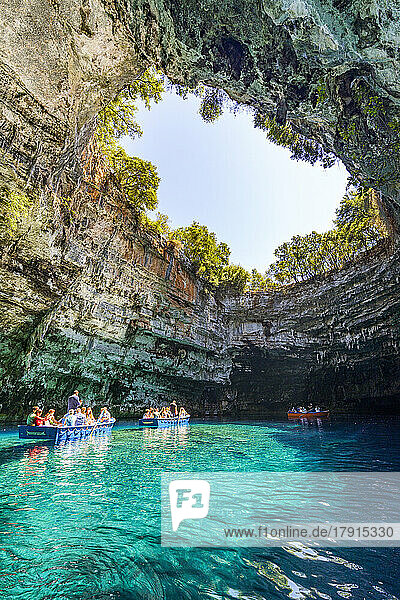 Touristen bewundern die Höhle während einer Bootsfahrt auf dem kristallklaren Wasser des Melissani-Sees  Kefalonia  Ionische Inseln  Griechische Inseln  Griechenland  Europa
