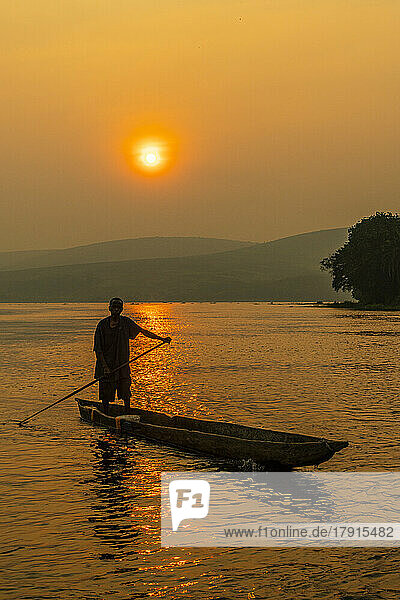 Mann in seinem Einbaum bei Sonnenuntergang auf dem Kongo-Fluss  Demokratische Republik Kongo  Afrika