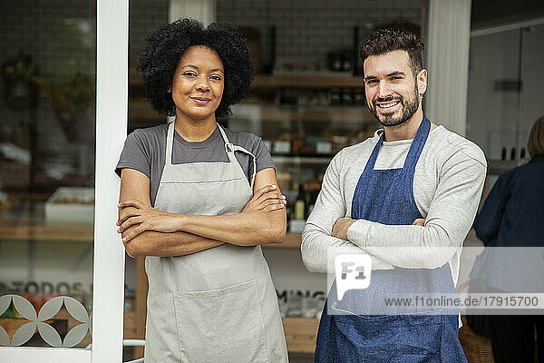 Bakery owners wearing apron standing with arms crossed