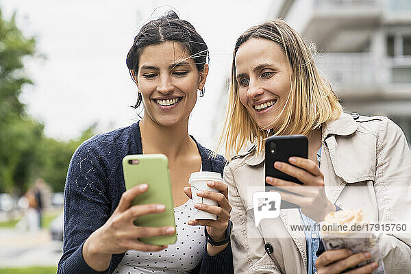 Mid-shot of two female freelance digital nomads looking at their online postings