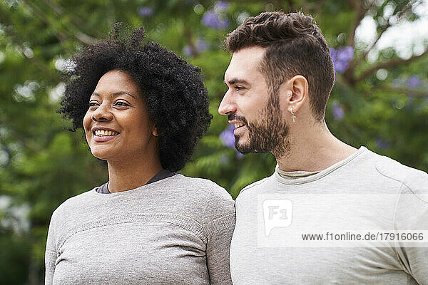Mid-shot portrait of an African-American woman and Caucasian man having a good time outdoors