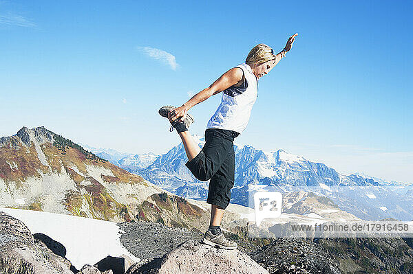 Woman doing balancing yoga pose on Mount Baker  Snoqualmie National Forest  North Cascades.