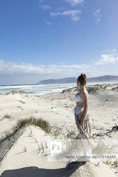 South Africa  Hermanus  Teenage girl (16-17) standing on beach in Walker Bay Nature Reserve