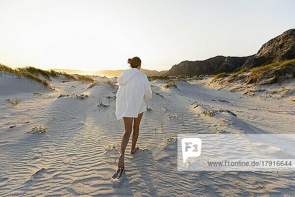 South Africa  Hermanus  Teenage girl (16-17) walking on sand dunes on Grotto Beach