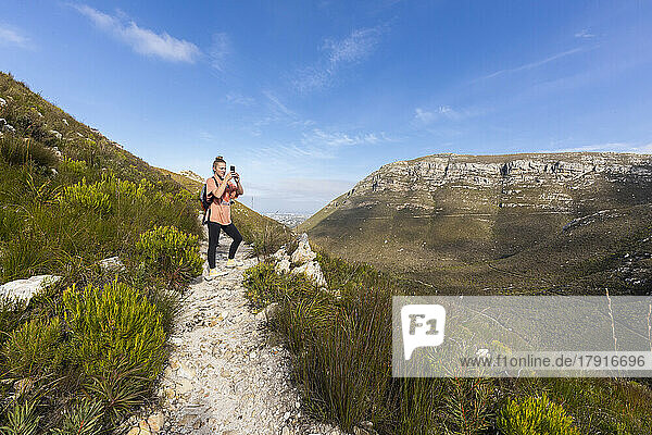 South Africa  Hermanus  Teenage girl (16-17) photographing landscape in Fernkloof Nature Reserve