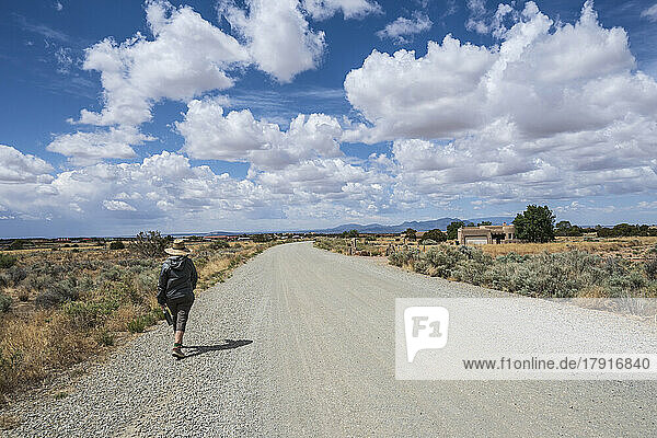 Usa  New Mexico  Santa Fe  Rear view of woman walking rural road
