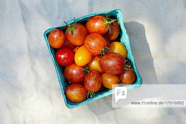 Overhead view of ripe red and yellow cherry tomatoes in carton