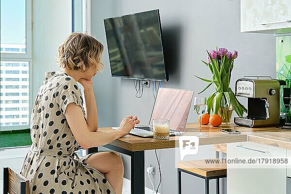 Frau führt einen Videoanruf mit einem Geschäftspartner  der einen Laptop benutzt und auf den Bildschirm mit virtuellem Webchat schaut
