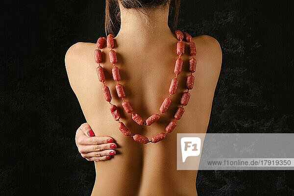 Rückenansicht einer Frau  die kleine Piccolini-Würstchen mit Gewürzen als Perlen trägt