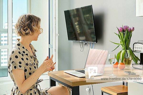 Woman making video call to business partner using laptop  looking at screen with virtual web chat