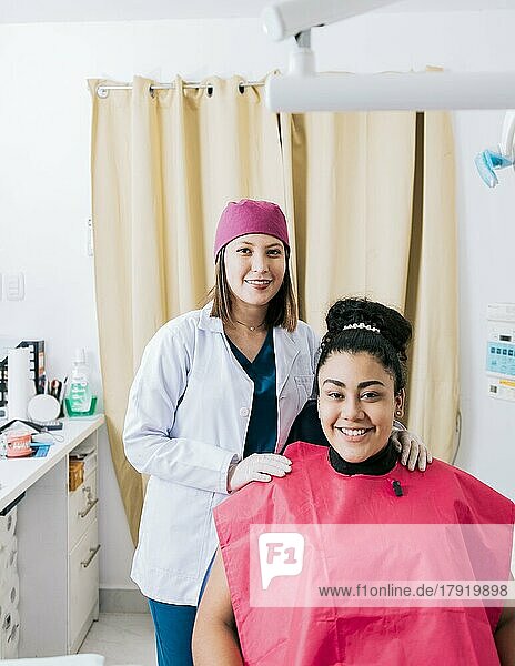 Porträt eines Zahnarztes mit einem in die Kamera lächelnden Patienten in der Praxis  Zahnärztin mit einem zufriedenen  in die Kamera lächelnden Patienten  Zahnärztin mit einem freundlich lächelnden Patienten