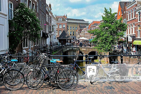 UTRECHT  NIEDERLANDE  25. MAI 2018: Fahrräder  die ein sehr beliebtes Transportmittel in den Niederlanden sind  parken in der Straße entlang des Kanals in der Nähe alter Häuser. Utrecht  Niederlande  Europa