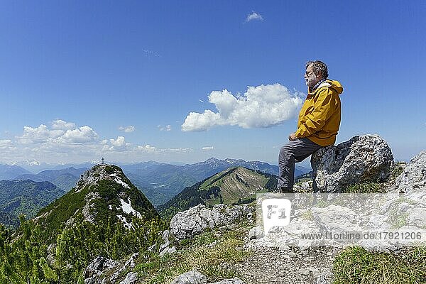 Wanderer  Senior  63  rastet am Gipfel des Buchstein  hinten Roßstein und Benediktenwand  Kreuth  Mangfallgebirge  Oberbayern  Deutschland  Europa