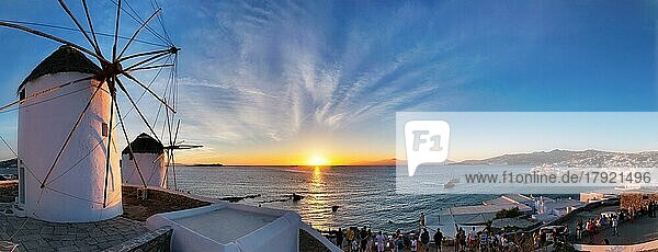 MYKONOS  GRIECHENLAND  29. MAI 2019: Panorama der traditionellen griechischen Windmühlen auf der Insel Mykonos bei Sonnenuntergang mit dramatischem Himmel und dem Viertel Klein-Venedig mit vielen Touristen