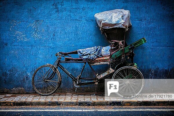 DELHI  INDIEN  11. SEPTEMBER 2011: Ein indischer Fahrrad-Rikscha-Fahrer schläft auf seinem Fahrrad in den Straßen von Neu-Delhi  Indien. Fahrrad-Rikschas wurden ab etwa 1930 in Kalkutta eingesetzt und sind heute in ländlichen und städtischen Gebieten Indiens weit verbreitet