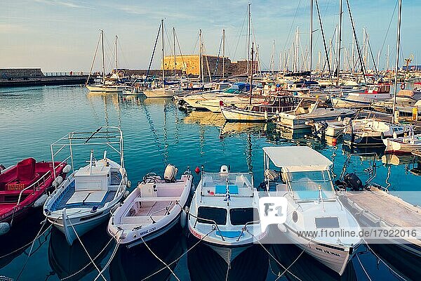 HERAKLION  GREECE  MAY 20  2019: Venetian Fort castle in Heraklion capital of Crete island and moored fishing boats on sunset