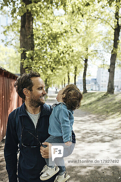 Glücklicher Vater schaut auf Kleinkind Junge Spaß im Park